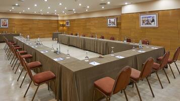 Uma sala de conferências com uma mesa comprida, cadeiras e placas de identificação.