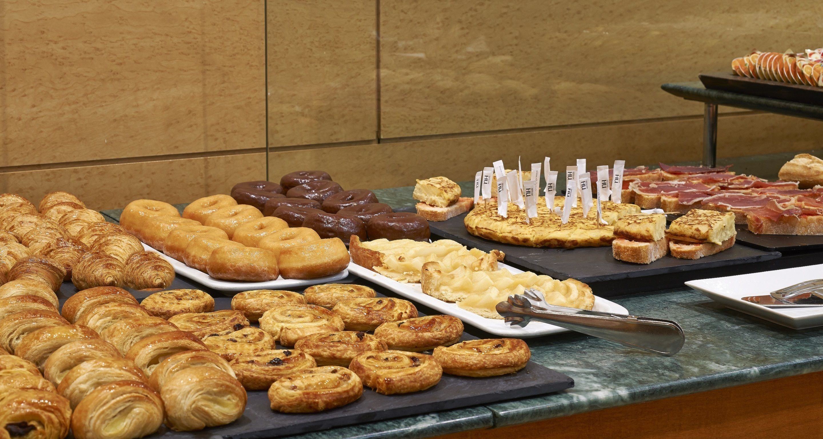 Un buffet proposant une variété de viennoiseries et de sandwichs.