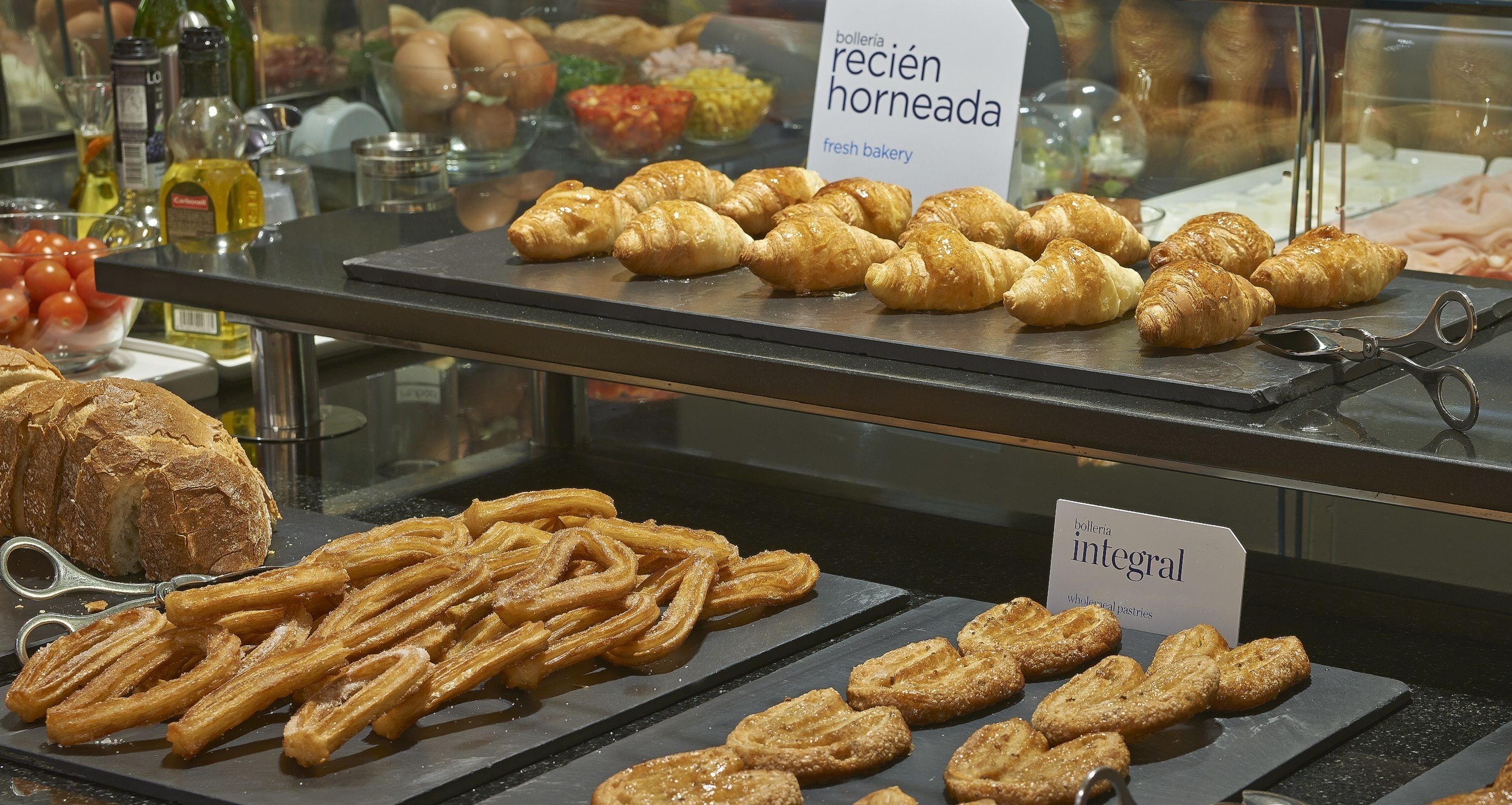 A bakery display with pastries and a sign indicating 'bodega integral'.