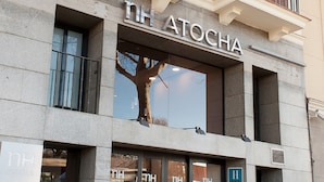 Eine Hotelsansicht, auf der der Name "NH ATOCHA" gut sichtbar angebracht ist.