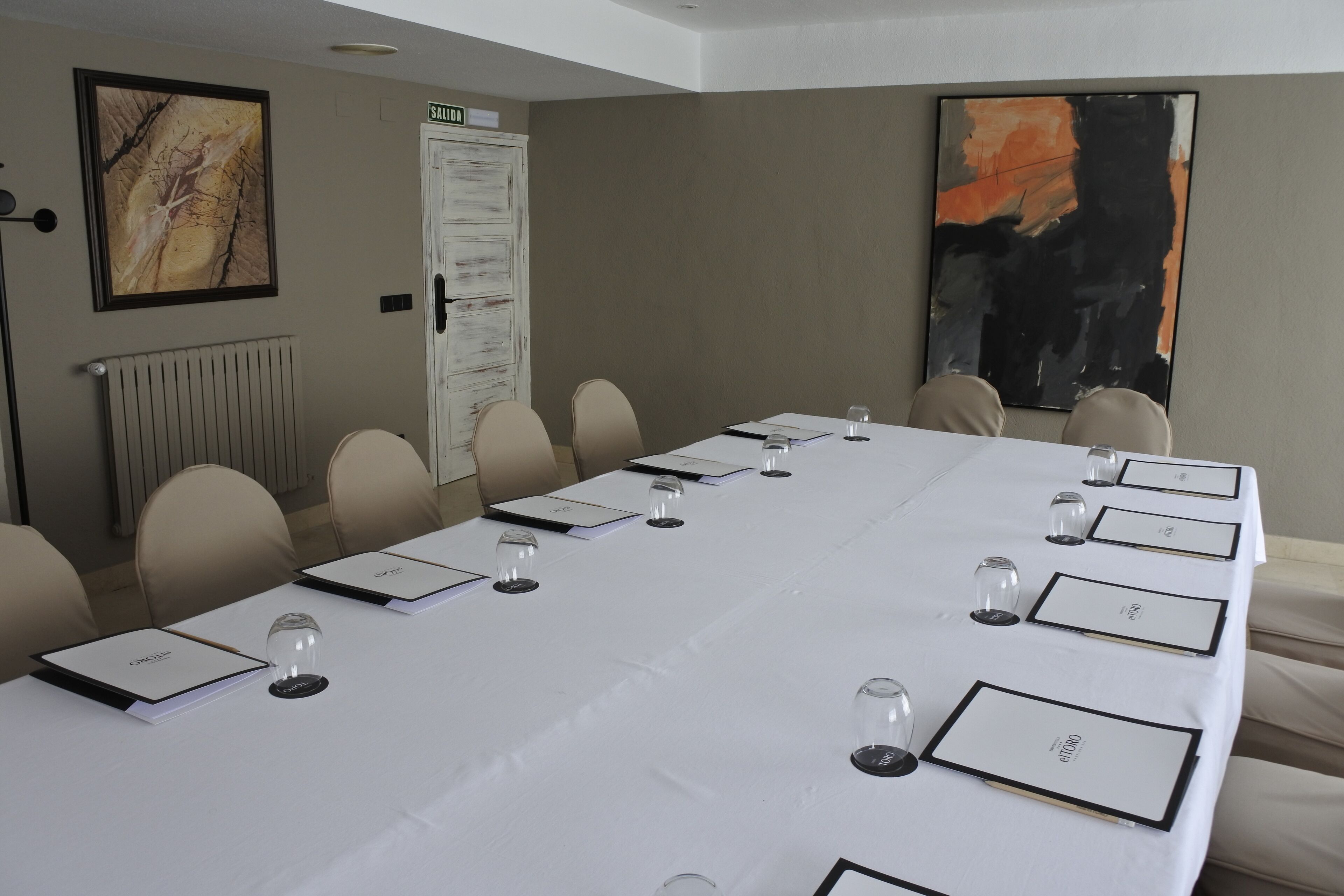 A conference room with a long table, nameplates, and chairs.