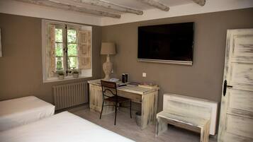 Un dormitorio con cama, escritorio, silla, televisor y armario.