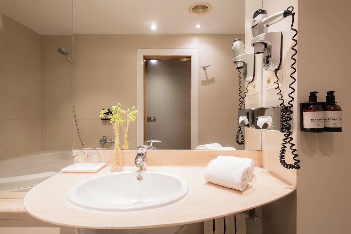 junior suite | bathroom | combined shower/bathtub, eco-friendly toiletries, hair dryer, towels