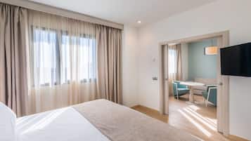A hotel room with a bed, a desk, and a TV.