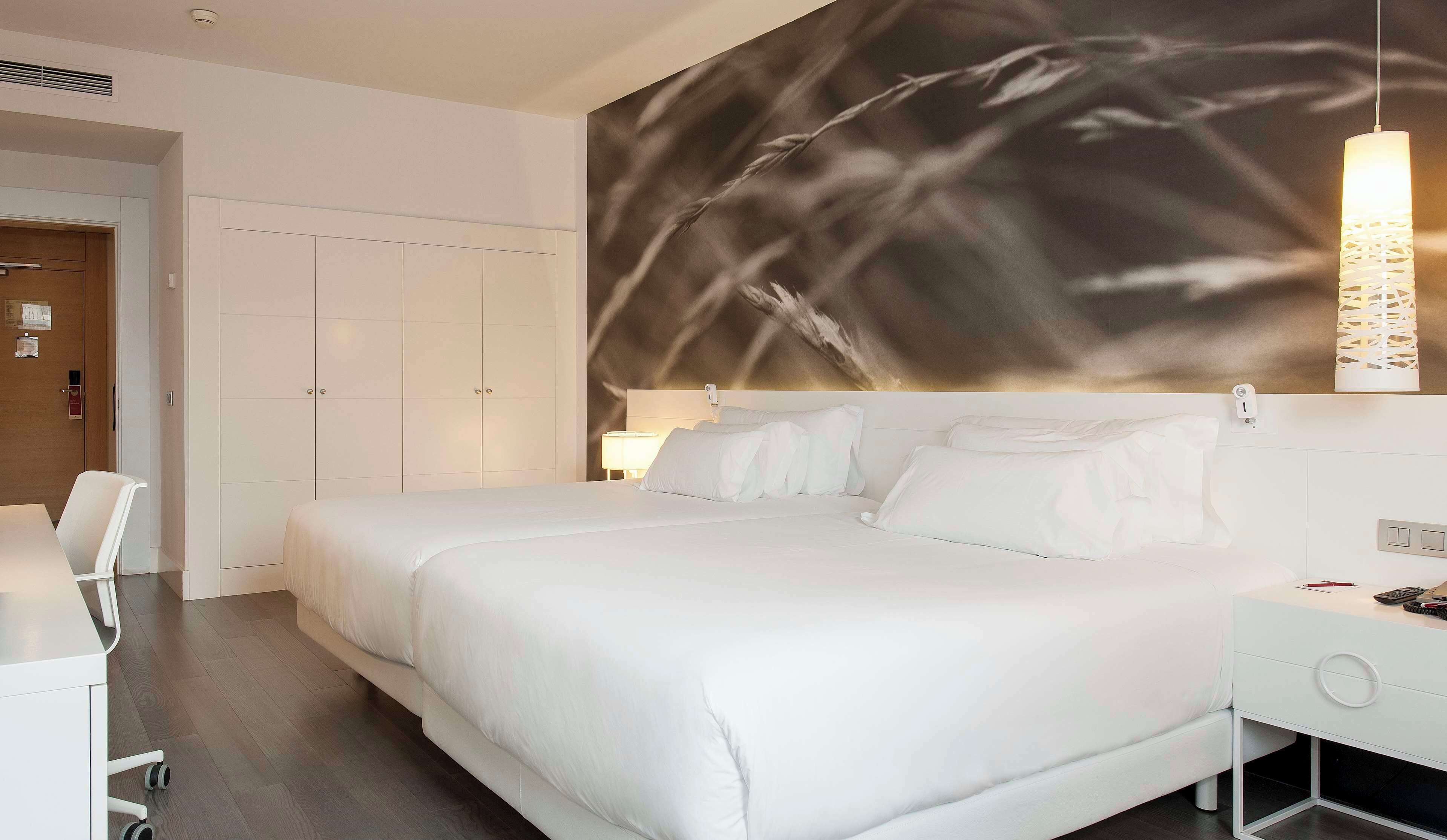 Una habitación de hotel con una cama grande, un escritorio y una silla.