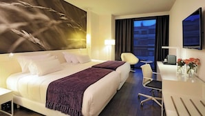 A hotel room with a large bed, a desk, a chair, and a TV. - NH Collection Villa de Bilbao (Bilbao)