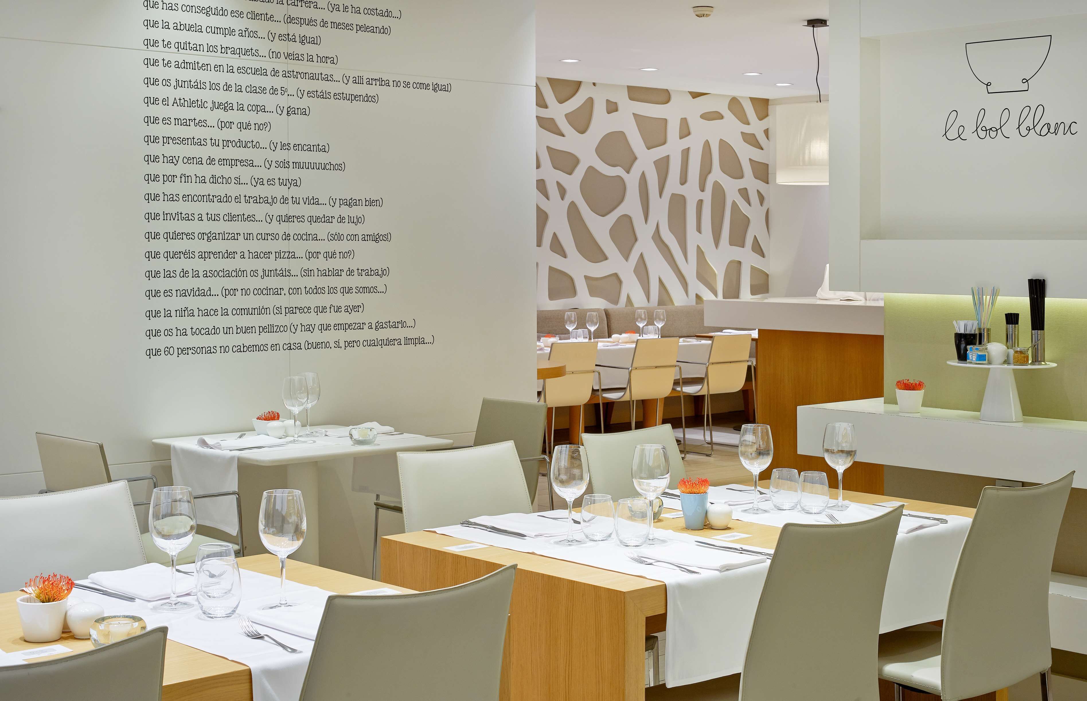 Interior moderno de restaurante com mesas e cadeiras organizadas e uma parede decorativa com padrão.