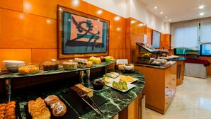 A buffet with various food items, a large framed artwork on the wall, and a television in the background. - Hotel Villacarlos (Valencia)
