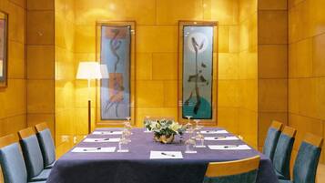Una sala conferenze con un lungo tavolo, sedie e opere d'arte alle pareti.