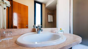 A bathroom with a white sink, a mirror, and a towel rack.