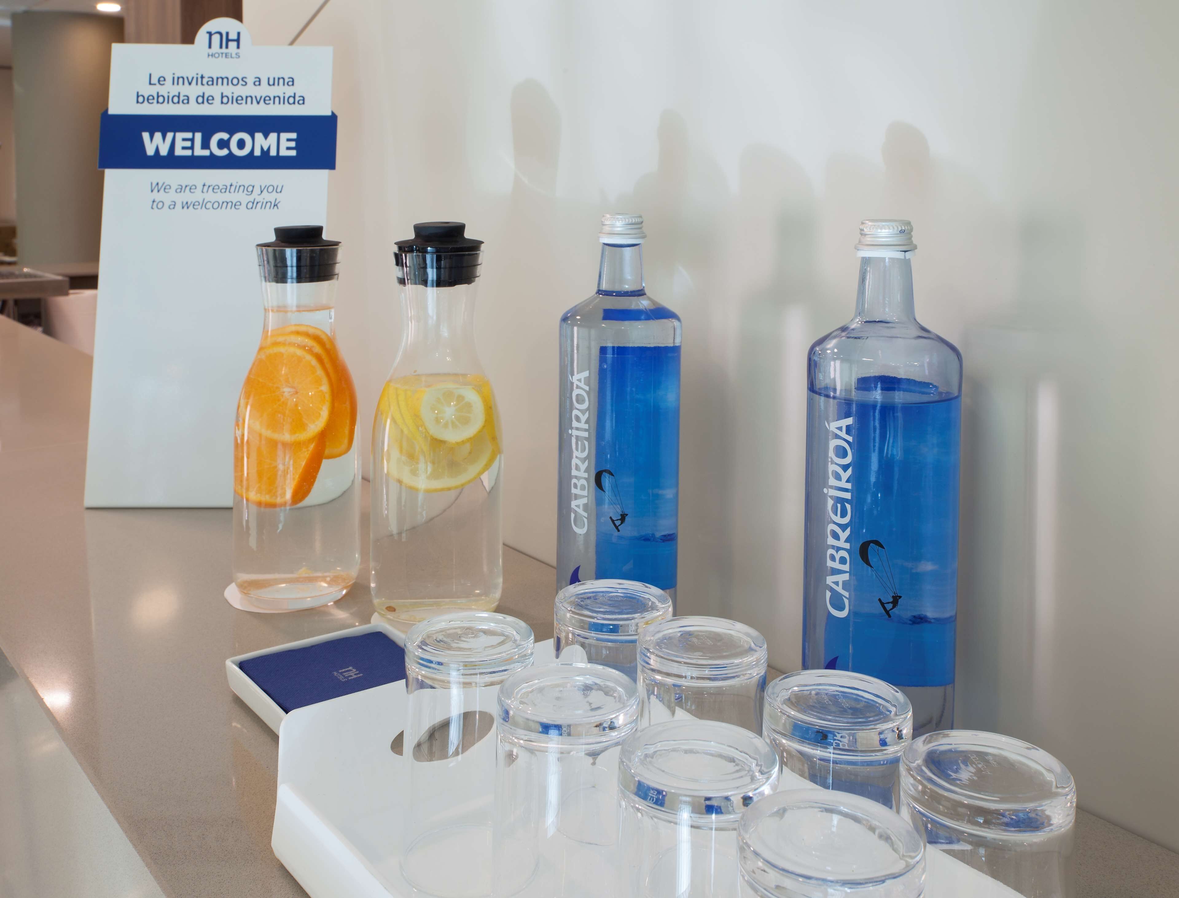 A welcome sign and various beverage bottles on a counter.