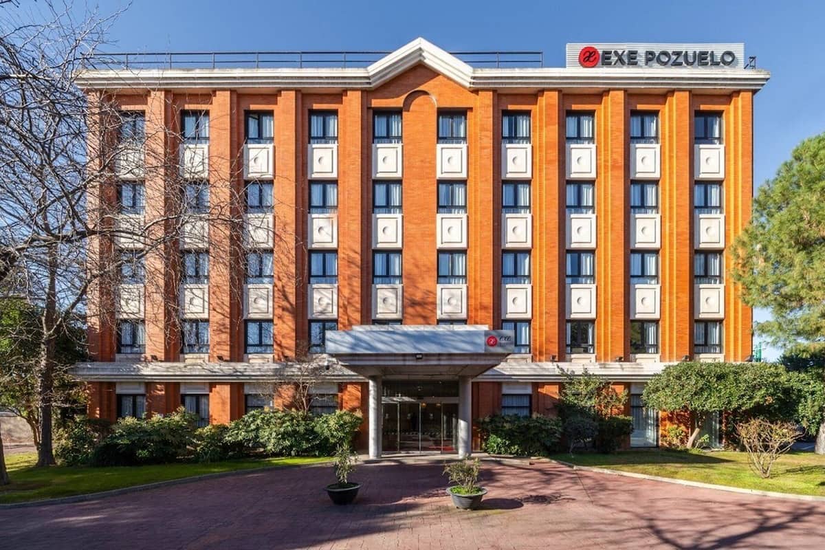 A multi-story hotel with a prominent entrance and a sign reading "EXE POZUELO".
