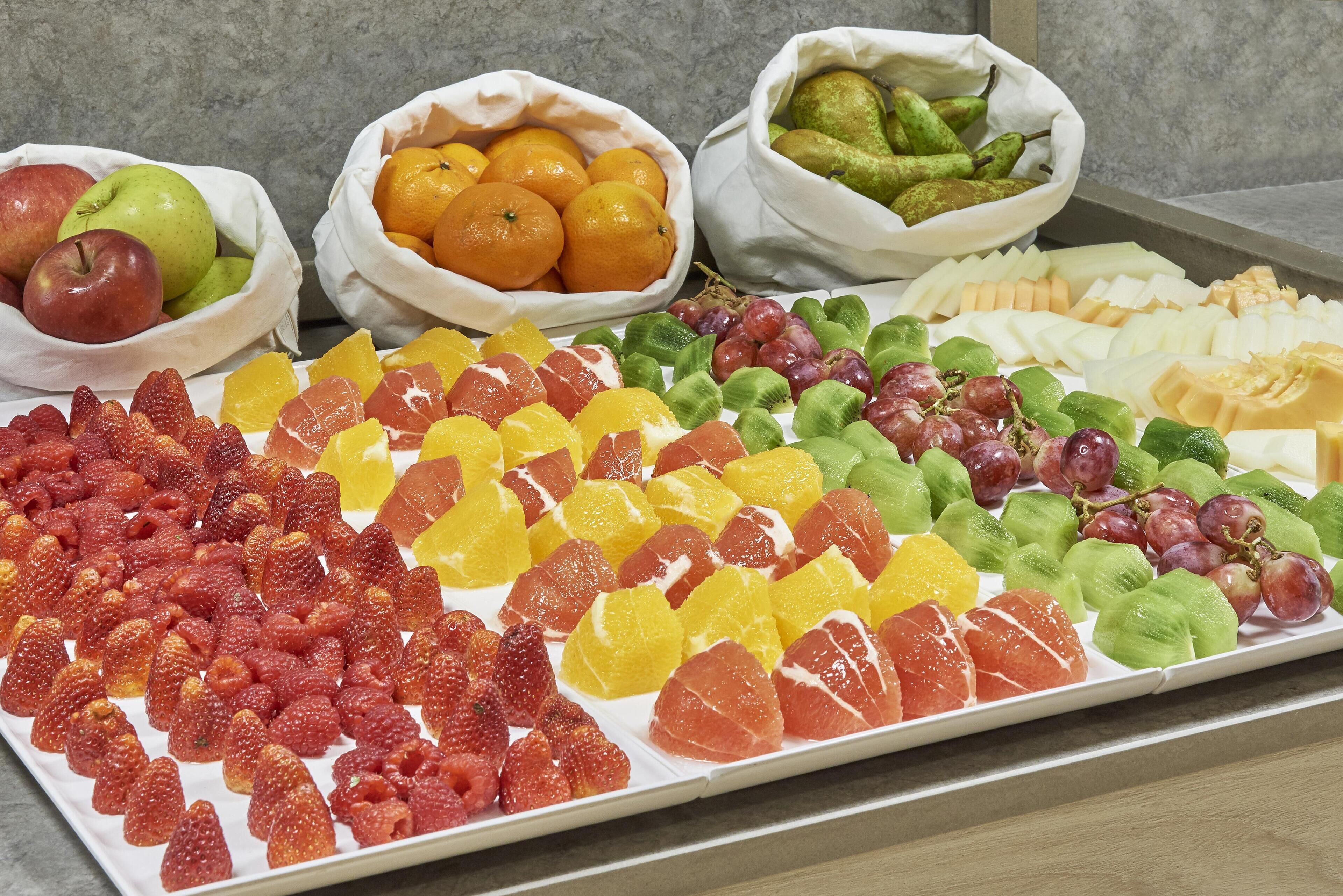 A variety of fruits and cheeses displayed on a tray.