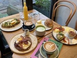 En morgenmadsopstilling med forskellige retter, kaffe og en menu.