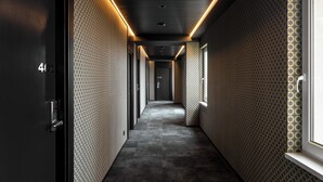 A hallway with patterned walls, a dark floor, and a door labeled "401". - Aida Hotel (Prague)