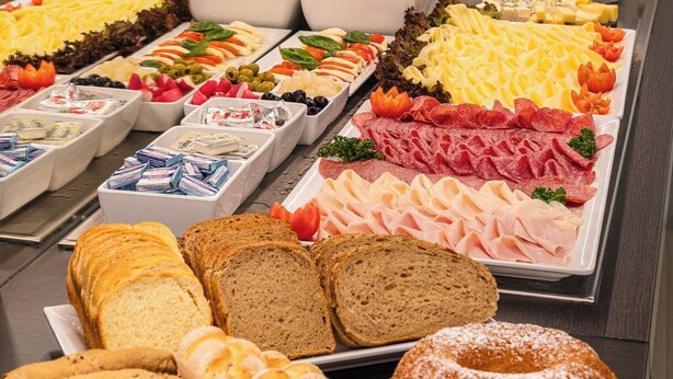 A buffet with various food items including fruits, cheeses, meats, and breads. - Aida Hotel (Prague)