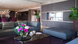 A modern lobby with grey sofas, a marble coffee table, and a vase of flowers. - Best Western Arlanda Plus Park Airport Hotel (Arlandastad)