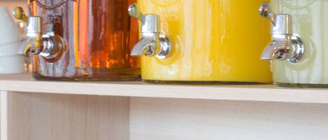 A wooden shelf with various bottles and a basket of bread.