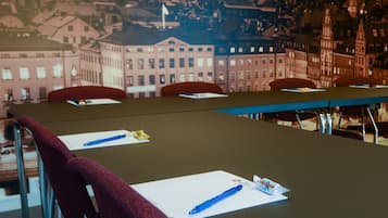 Een vergaderruimte met een lange tafel, stoelen en uitzicht op een stadsgezicht door een raam.