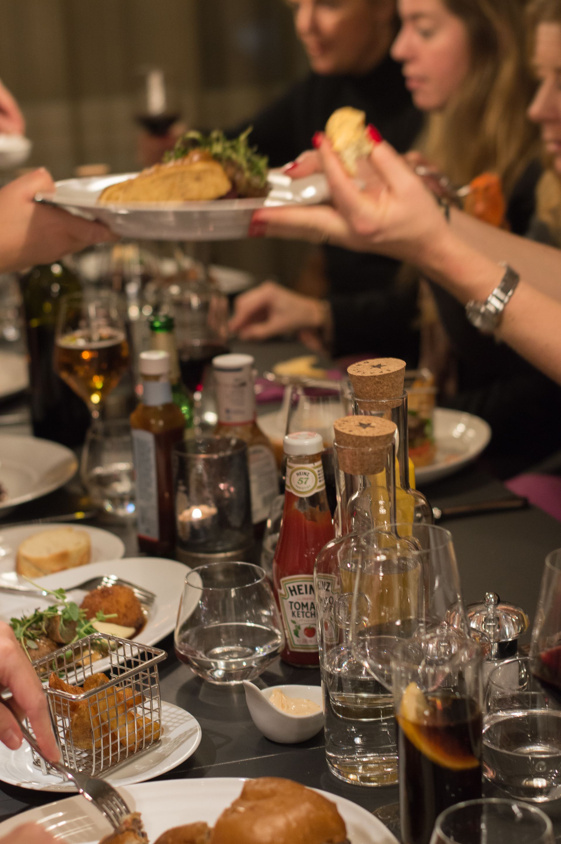 Une table à manger avec différents plats, des bouteilles et des verres.