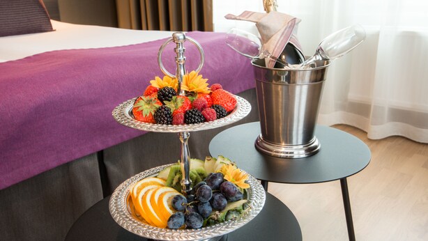 A three-tiered fruit stand with strawberries, blackberries, and blueberries on a table in a hotel room. - Best Western Arlanda Plus Park Airport Hotel (Arlandastad)