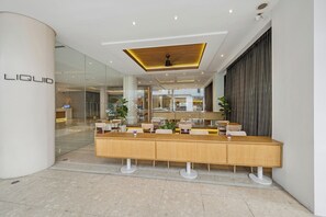 A modern interior with a reception desk, glass walls, and a ceiling with recessed lighting. - BelAire Bangkok Sukhumvit (Bangkok)