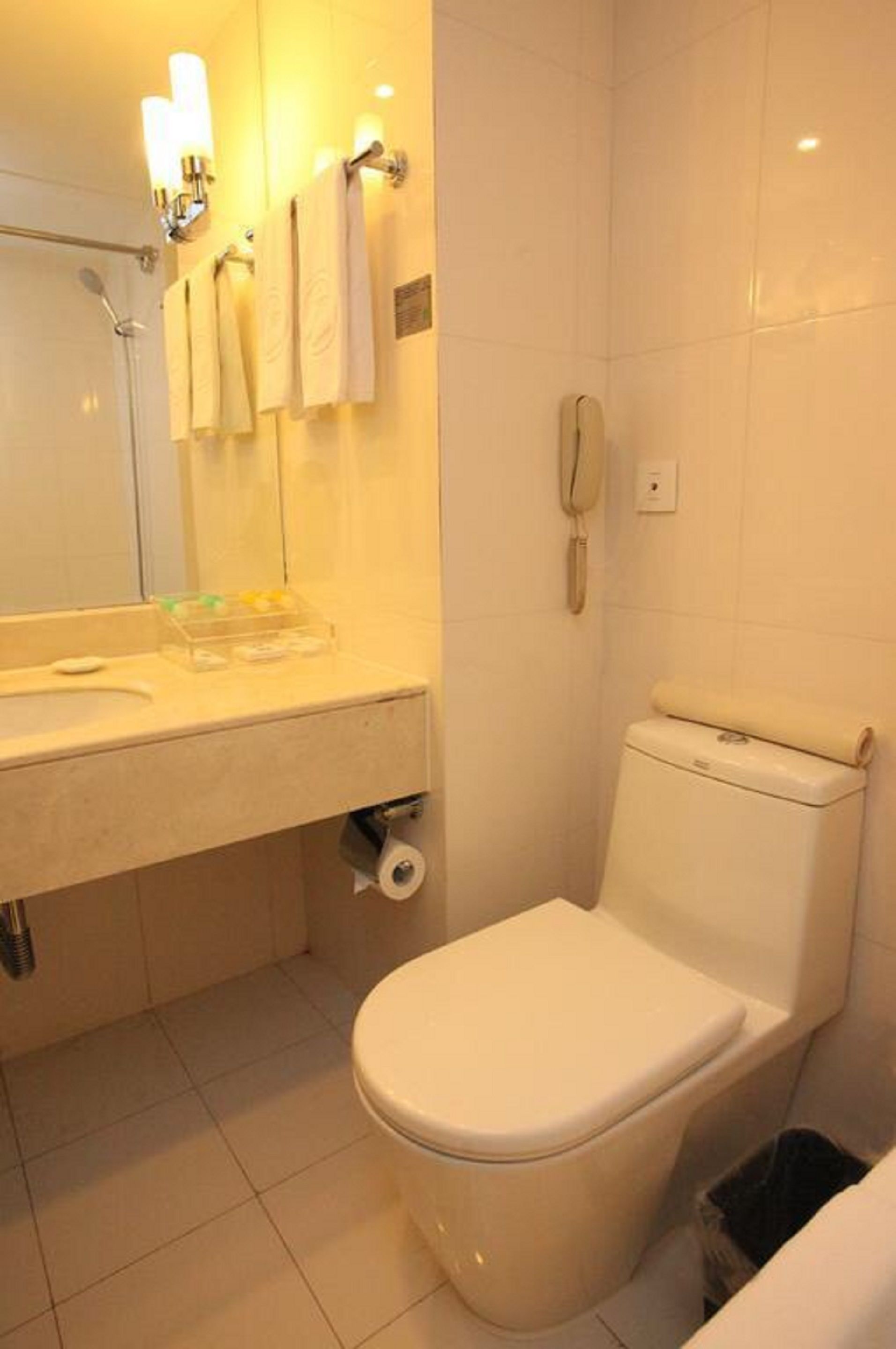Un baño con inodoro, lavamanos y espejo.