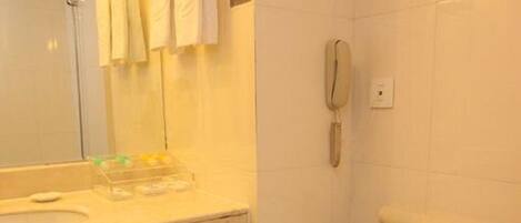 Un baño con inodoro, lavamanos y espejo.