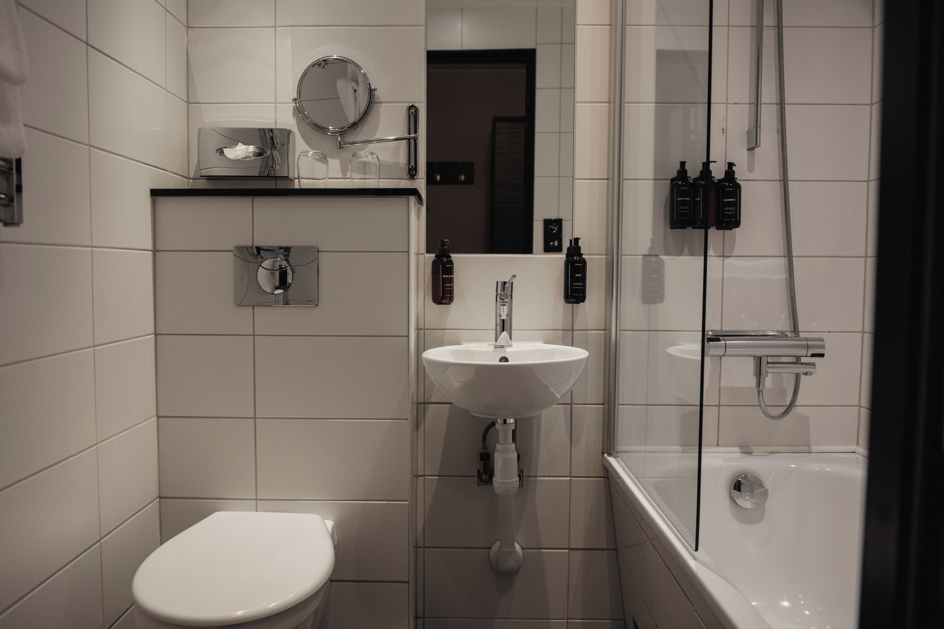 A modern bathroom with a toilet, sink, and bathtub.