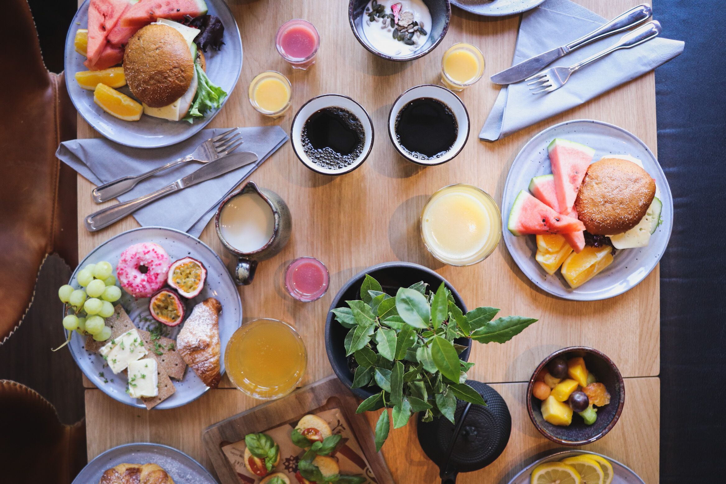 A breakfast table with various food items and drinks.