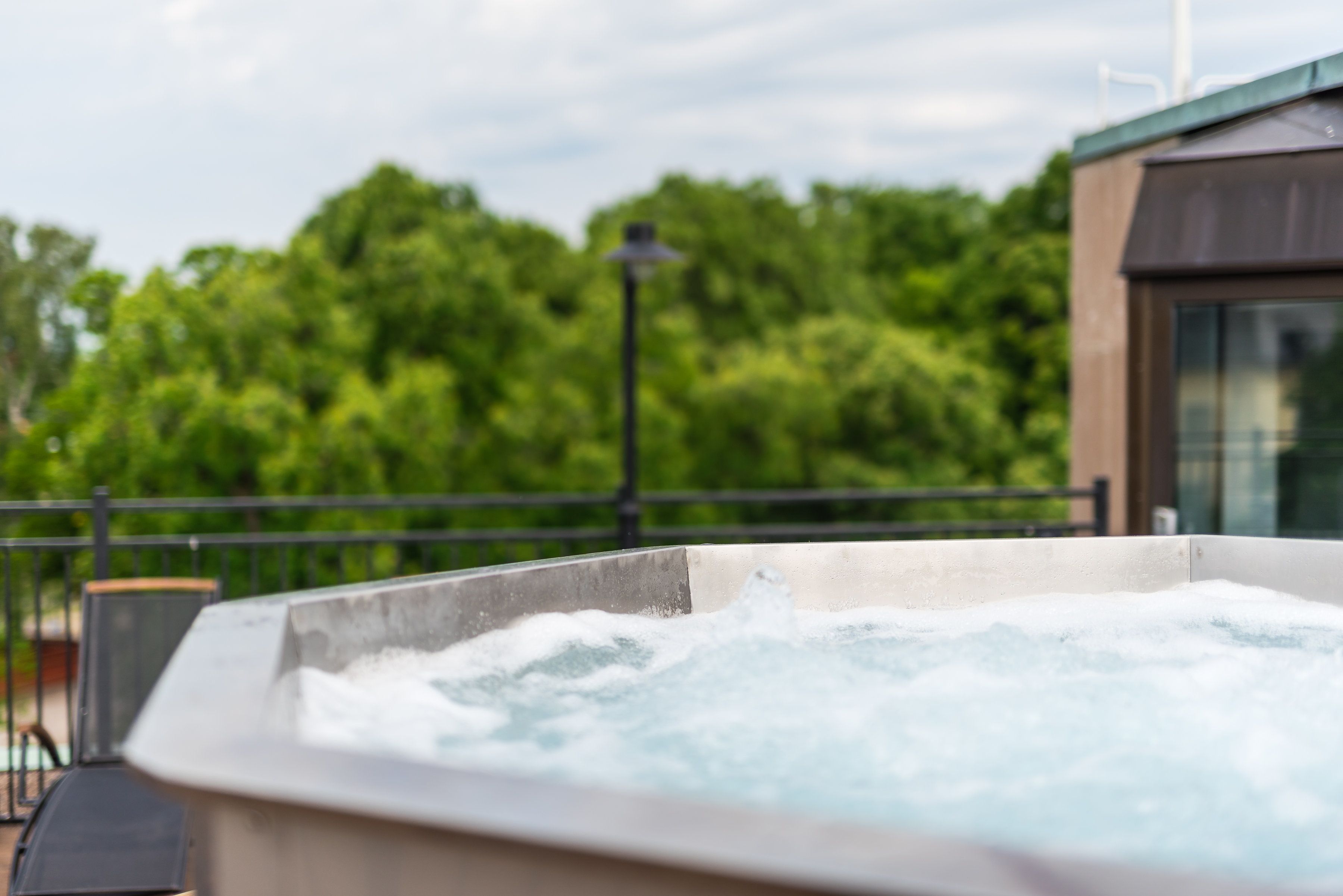 A hot tub with a view of lush green trees in the background.