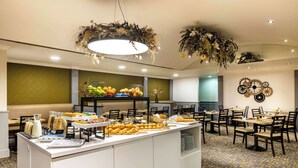 Un espace buffet proposant divers plats et une zone de restauration avec des tables et des chaises.