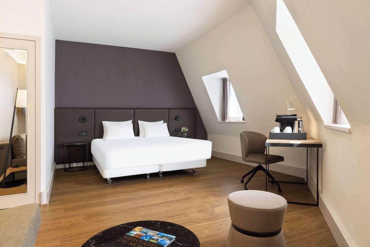 Une chambre à coucher moderne avec un grand lit, un bureau et une chaise.