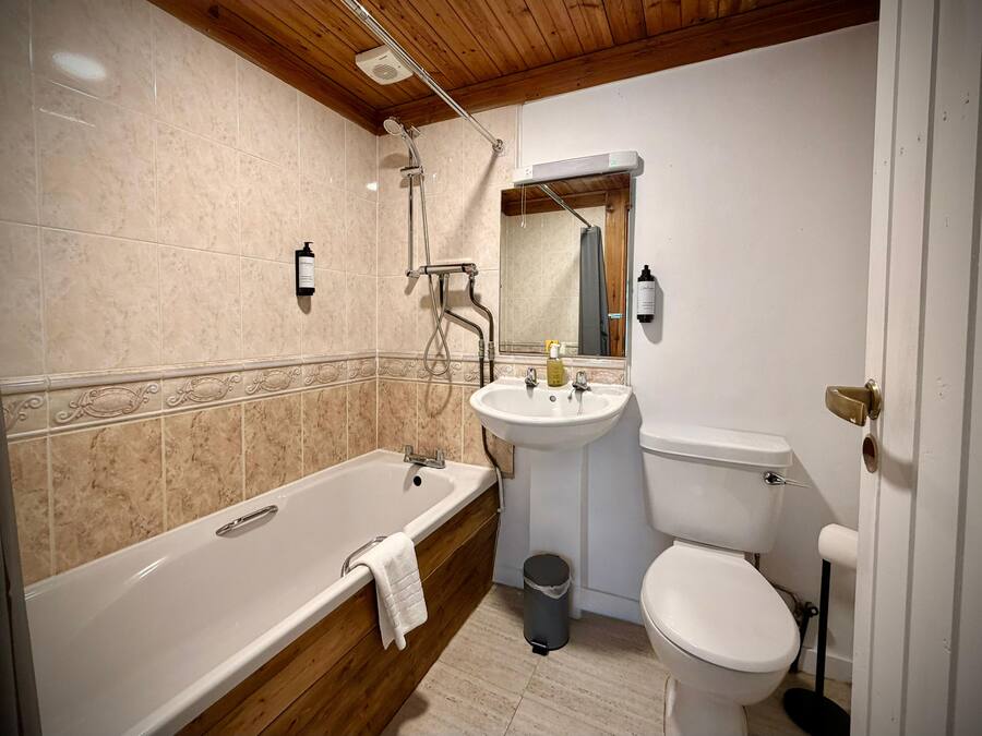 A bathroom with a bathtub, a sink, and a toilet.