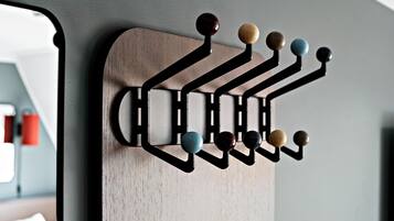A wall-mounted wooden rack with multiple hooks.