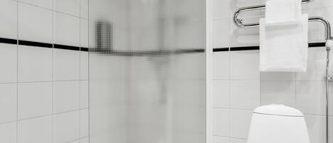 Une salle de bain moderne avec une douche à parois de verre, des toilettes blanches et un porte-serviettes.