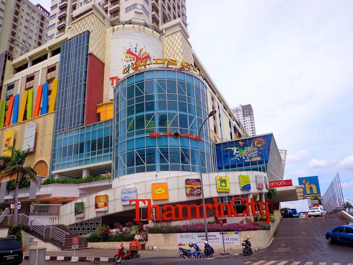 Un immeuble à plusieurs étages, reconnaissable à son grand panneau «  Thamrin City », ainsi qu’à une variété d’enseignes commerciales et à un mélange d’architecture moderne et traditionnelle.