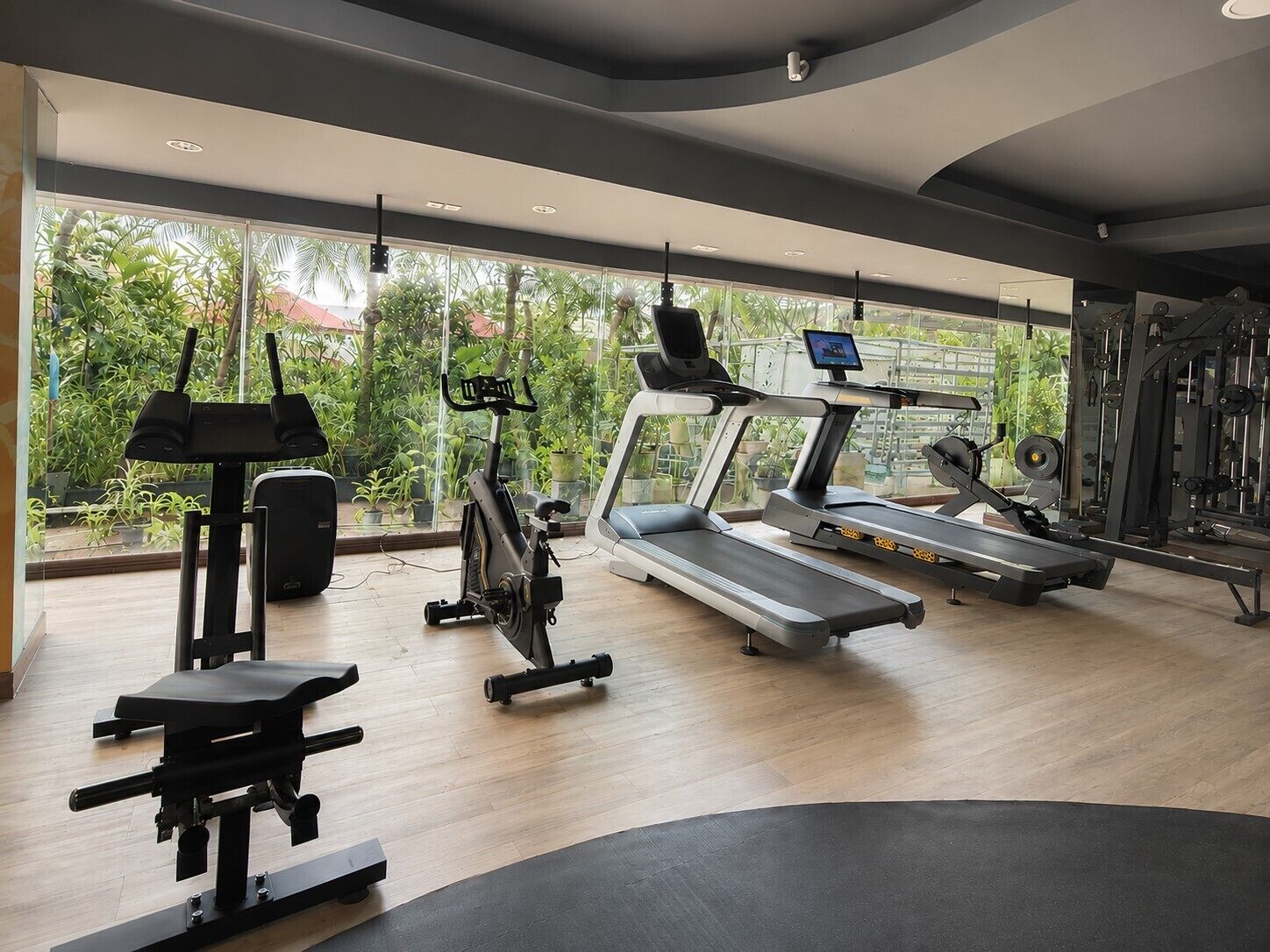 Une salle de sport équipée de tapis de course, de vélos d’exercice et d’appareils de musculation.