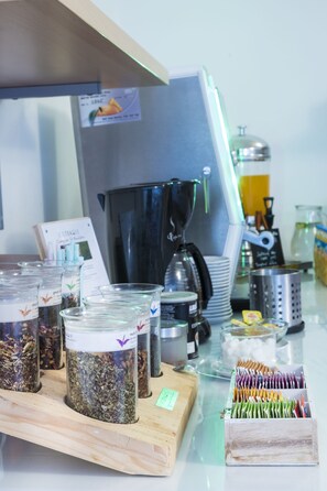 A coffee shop counter with various coffee beans, a coffee machine, and a menu board. - Art Hotel Meda of Museum Kampa (Prague)