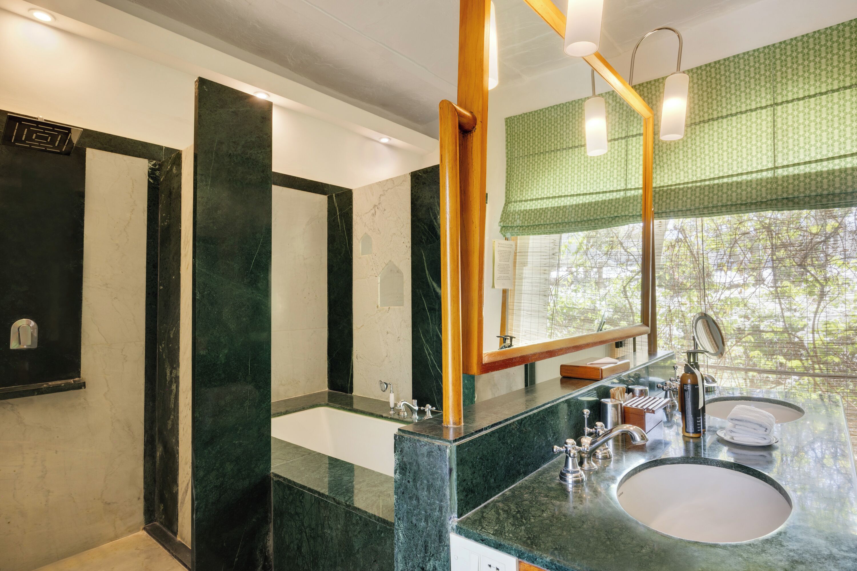 A bathroom with a large mirror, two sinks, and a window with a view.