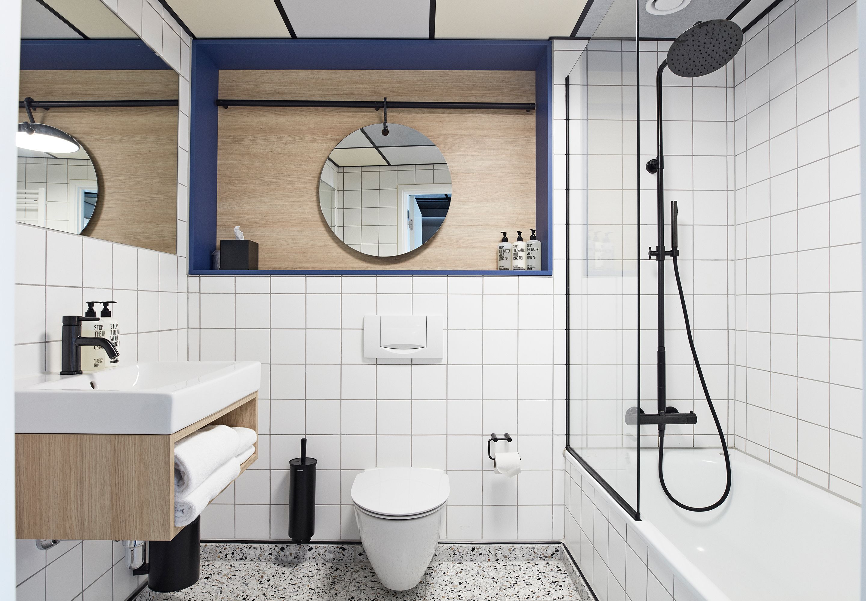 A modern bathroom with a white sink, toilet, and shower.