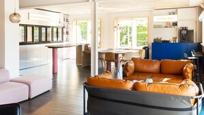 A modern interior with a leather sofa, a coffee bar, and a snack area. - CPH Hotel (Copenhagen)