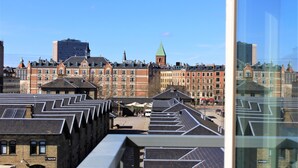 A cityscape with historic buildings and modern architecture, including a prominent church tower. - CPH Hotel (Copenhagen)