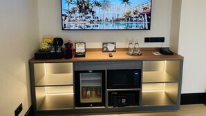 Zona de recepción de un hotel con un televisor mostrando una imagen de un resort tropical y el texto "HAVE A WONDERFUL STAY".