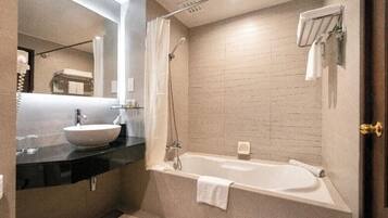 A modern bathroom with a large sink, a bathtub, and a shower.