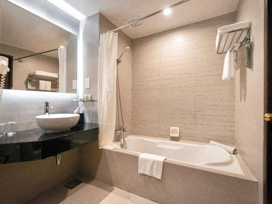 A modern bathroom with a large sink, a bathtub, and a shower.