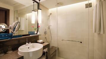 A modern bathroom with a large sink, mirror, and shower.