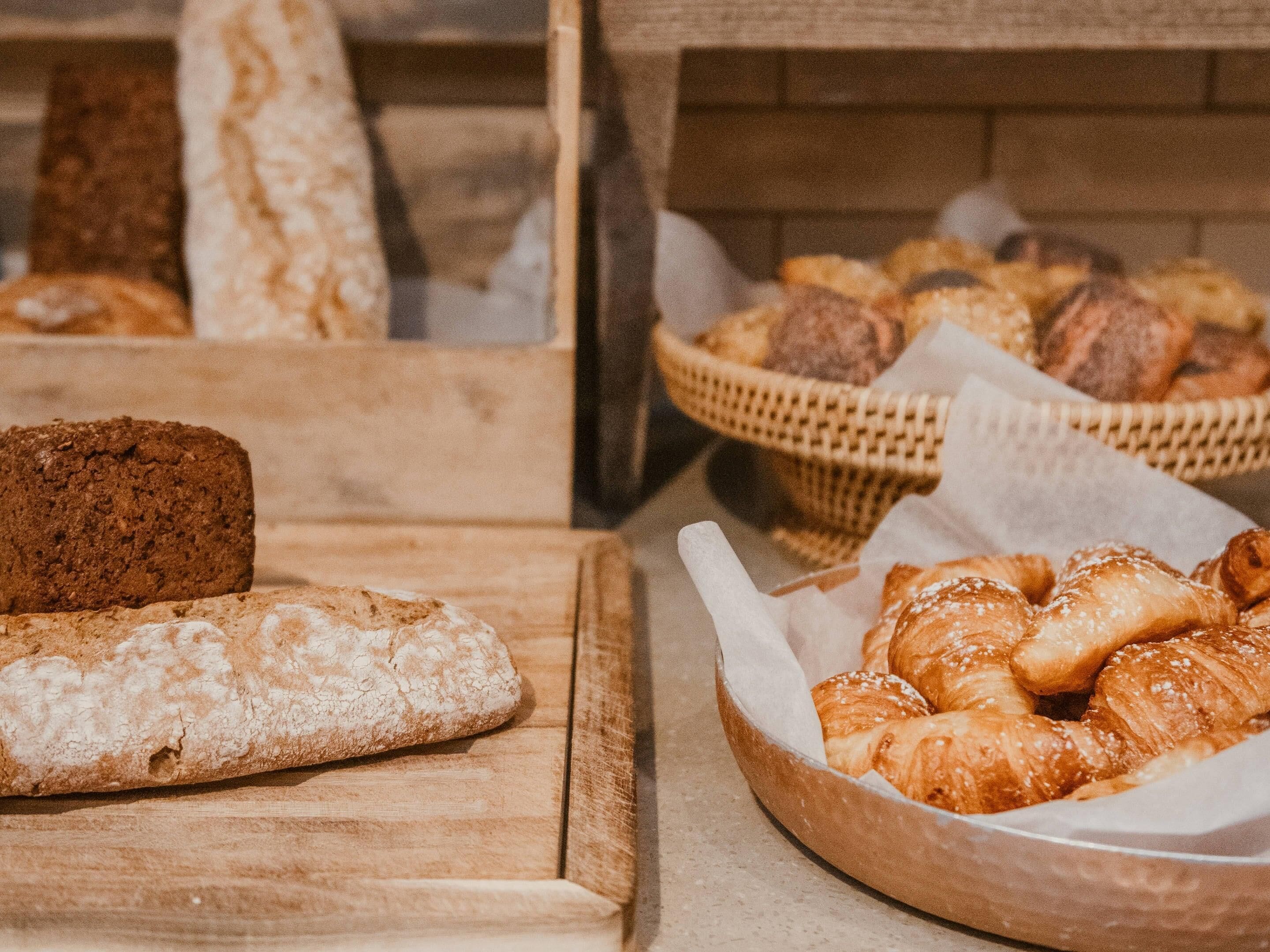 A bakery display with various breads and pastries.