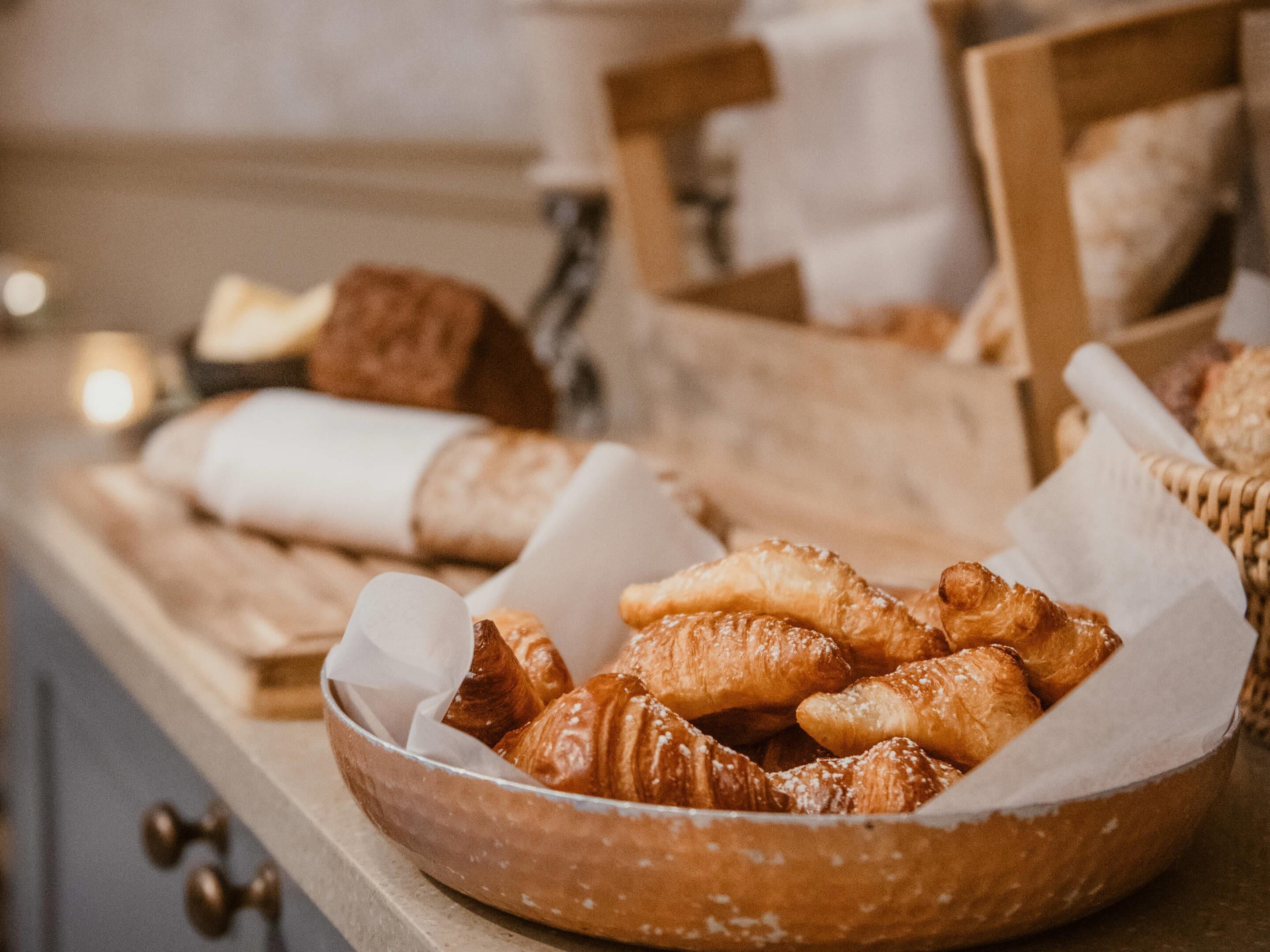 A variety of baked goods in a wooden bowl on a countertop.