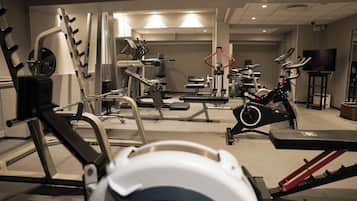A gym with various exercise equipment including treadmills, stationary bikes, and weight machines.
